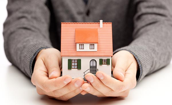 Man holding a small model of a house in his hands